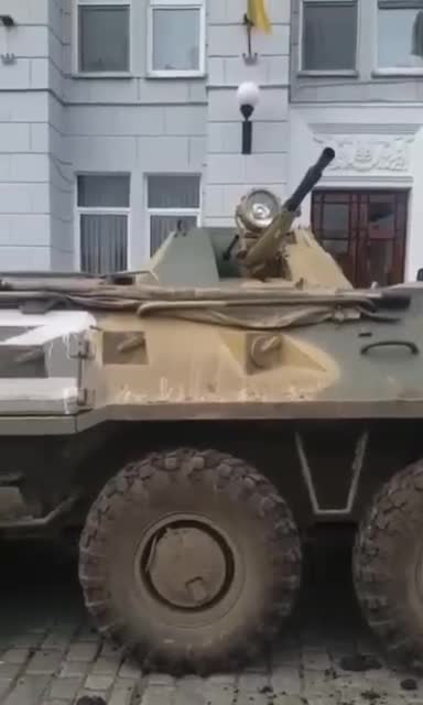 People in the square sing the anthem, right in front of the military