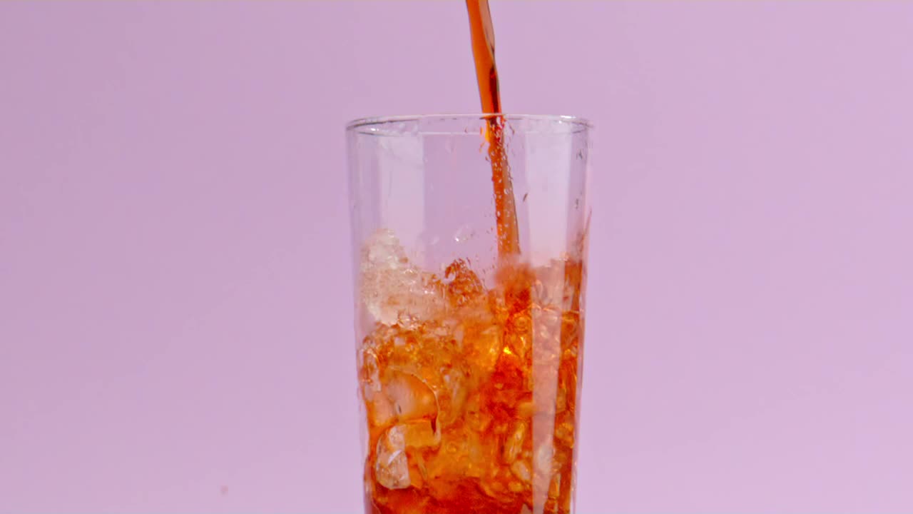 A stream of soda fills up a crystal glass