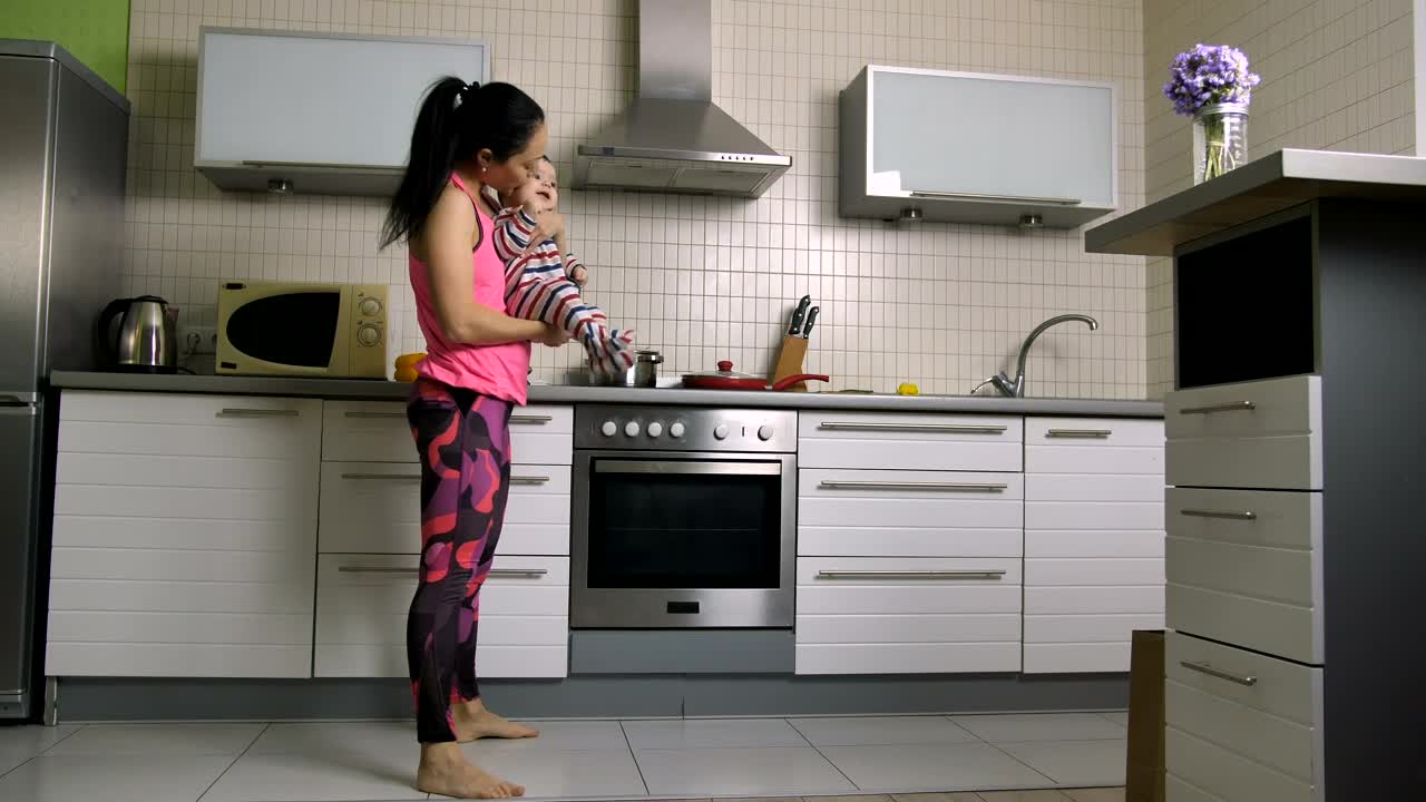 Woman doing squats with her baby in arms
