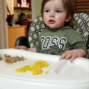 Baby laughs at sister blowing air in a bottle