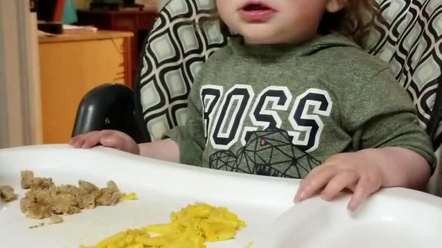 Baby laughs at sister blowing air in a bottle