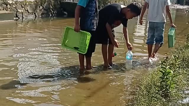 the flood slowly began to recede, the children around tried to catch fish part1