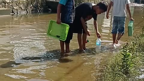 the flood slowly began to recede, the children around tried to catch fish part1