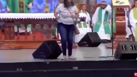 Some woman pushes a priest off the stage