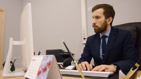 A Man Sit at Desk in Front Computer Working on Business Plan