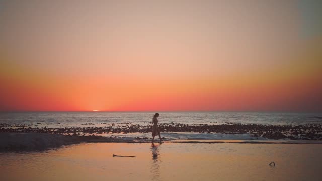 Lovers walking on the beach in the sunset