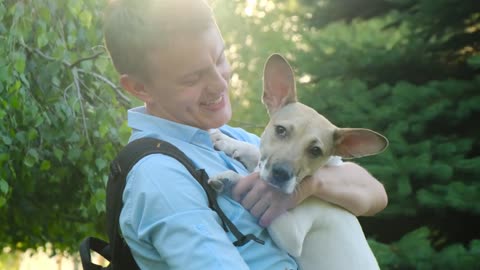 Puppy loves his master and kisses close up