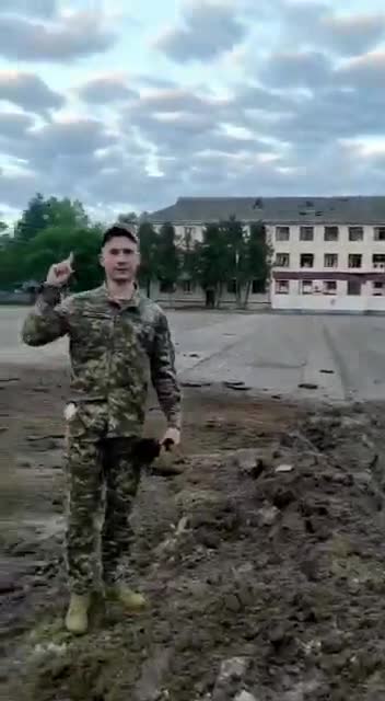 A bomb crater on the parade ground of the 169th training center