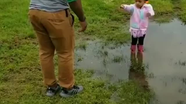 A girl child is fun to have | Look how she persuades her uncle to play in dirty water.