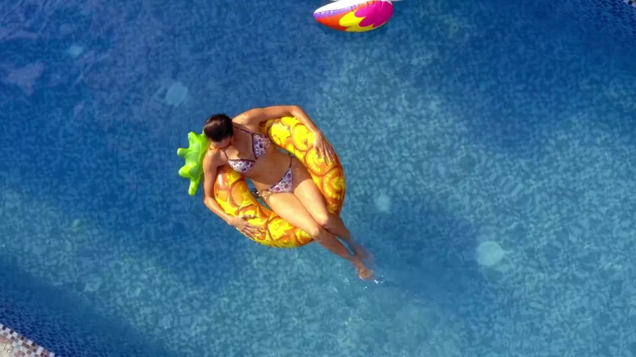 A young woman seen from above on a pineapple.