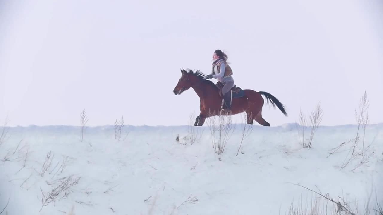 Young woman galloping on snowly outdoor on red horse