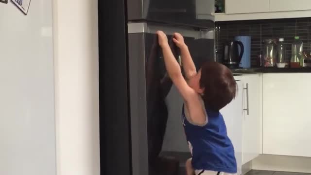 Cute spider man toddle try to climb the fridge