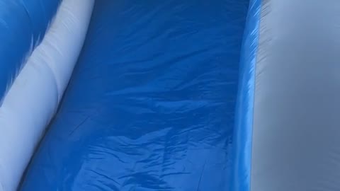 Boy in orange down blue slide