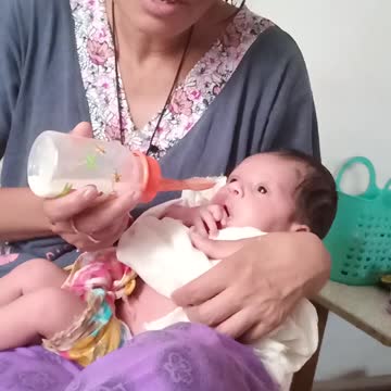 The mother feeds the child with milk.