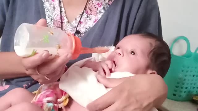 The mother feeds the child with milk.