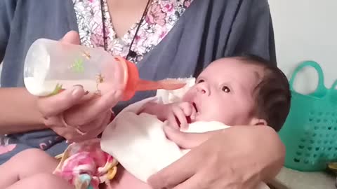 The mother feeds the child with milk.