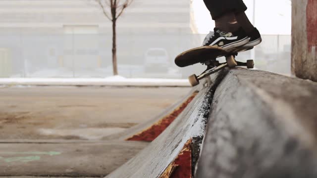 Slow Motion Footage Of A Skateboarder Doing Tricks On the Street Side Under A Bridge