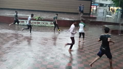 Street football. Rainy day. Enjoining playing