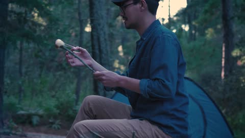 Small family eating roasted marshmallows in nature