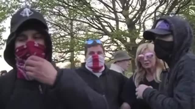 Lady sees an agitator in the crowds and tells him to foff because he is there to cause trouble