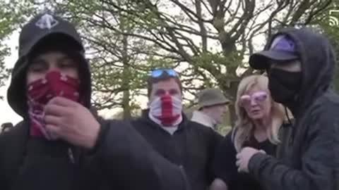 Lady sees an agitator in the crowds and tells him to foff because he is there to cause trouble