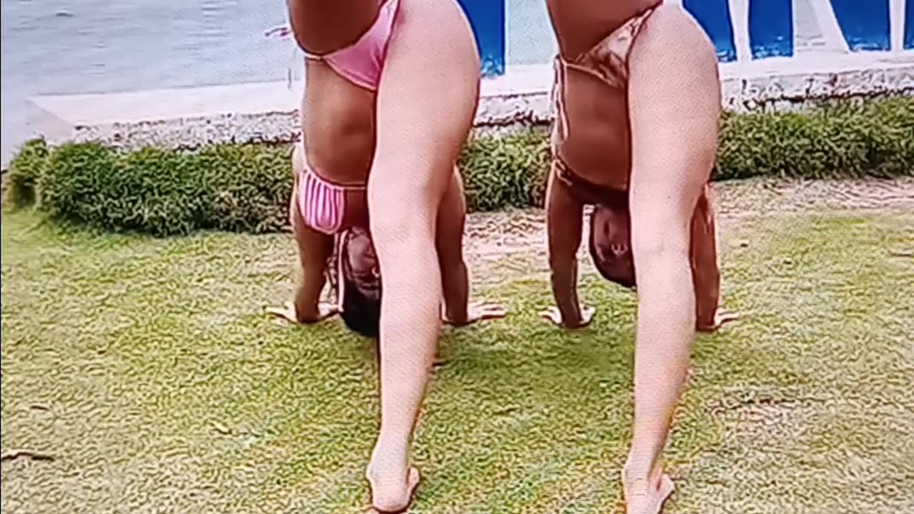 2 friends doing yoga by the water