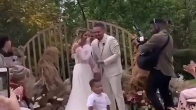 Cute baby boy given a gift to wedding couple