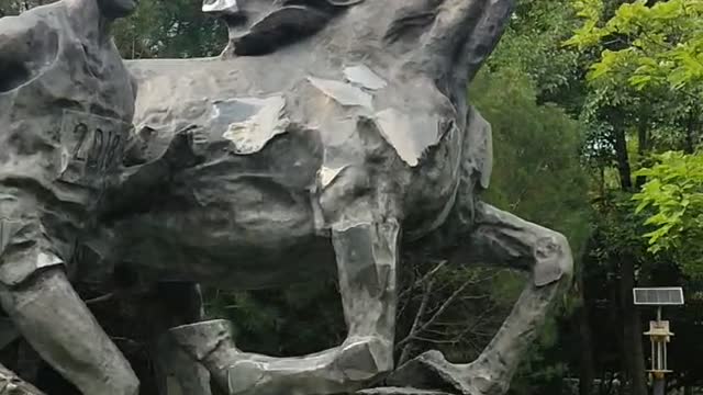 Sculpture of horse and man running together