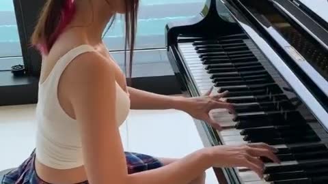 The sexy girl is playing the piano...