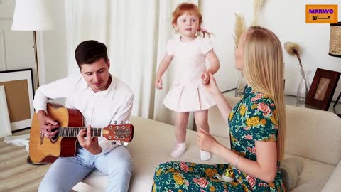 A father plays music and his daughter dances