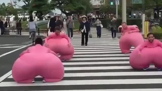 Passers-by watched as a group of young men dressed in pink sausages crossed the road