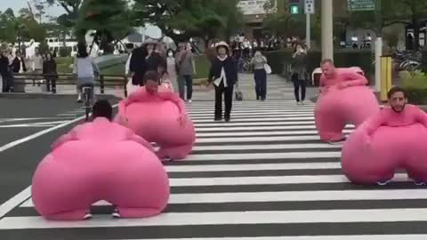 Passers-by watched as a group of young men dressed in pink sausages crossed the road