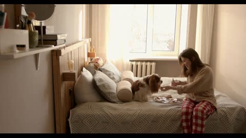 Attractive young woman walks into her bedroom with a plate of cookies and a cup of drink