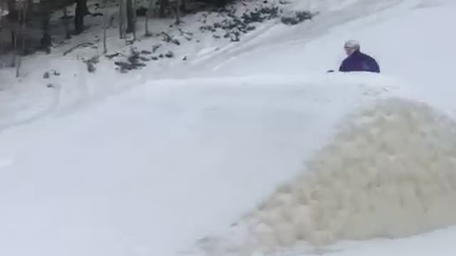 Girl in purple skis over small hill and crashes in snow