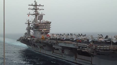 Carrier IKE underway at sea with jets on flight deck for UNREP with USNS Bighorn MSC ship.