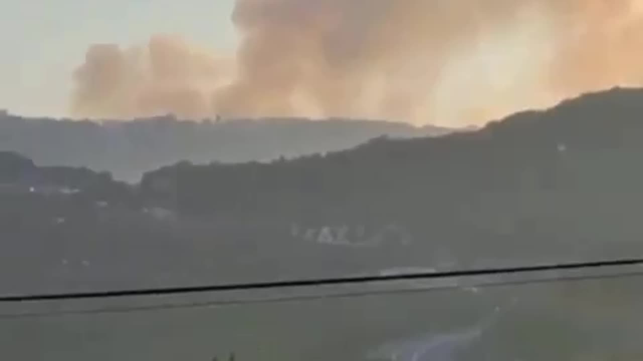 Large billows of smoke rise from an Israeli military base on Mount Meron