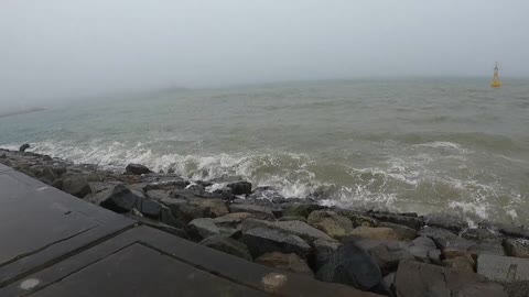 A beach near a cloudy lighthouse.