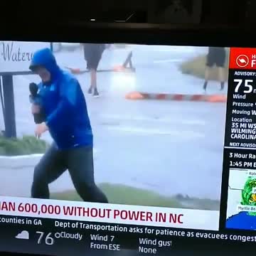 Weather Channel reporter braces against wind as others just stroll by