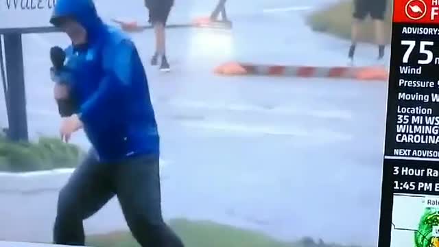 Weather Channel reporter braces against wind as others just stroll by