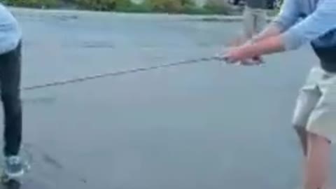 Two teens on skateboard hold on to white jeep