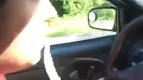 Man in red shirt throwing up while driving