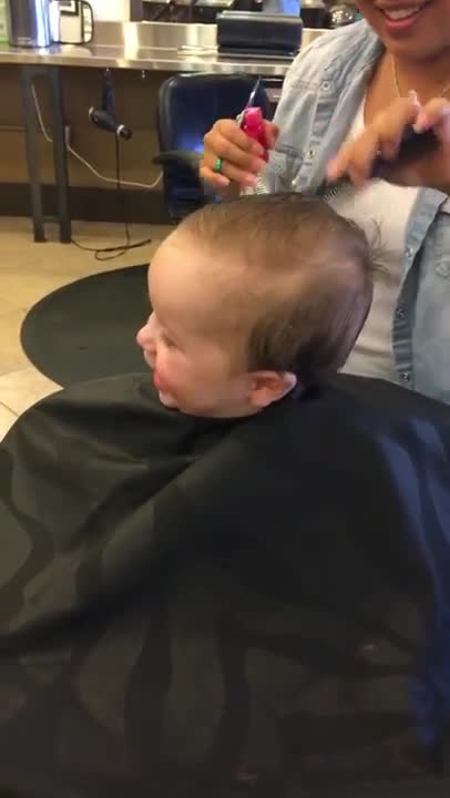 A este bebé le causa mucha gracia su primer corte de pelo