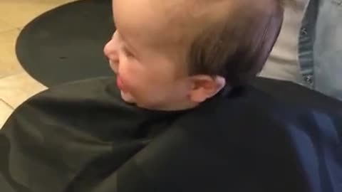 A este bebé le causa mucha gracia su primer corte de pelo