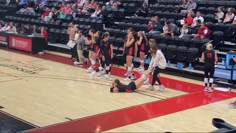 Volleyball player sliding on the floor as her team gets a kill