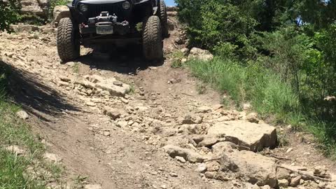 Jeep TJ coming down a rocky wash