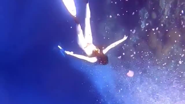 A girl diving under the sea showing beautiful views