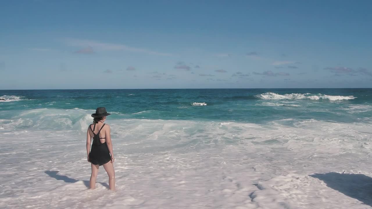 Woman with feet in ocean