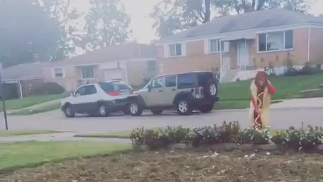 Black white dog chasing guy in hot dog costume