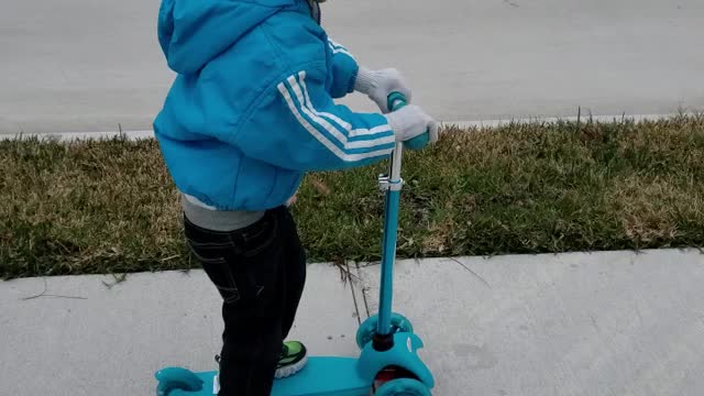 My 4 year old brother riding his scooter