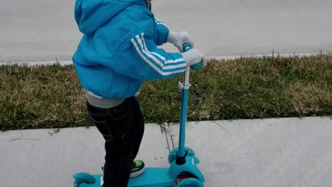 My 4 year old brother riding his scooter